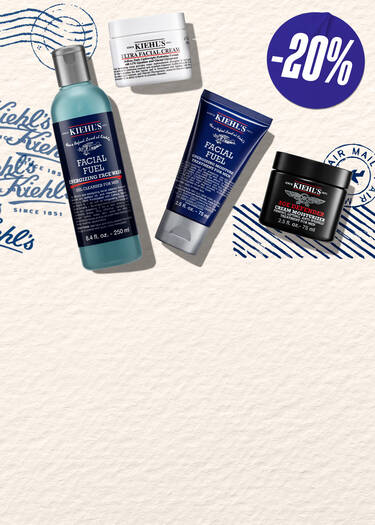 Een promotiebanner van Kiehl's voor Vaderdag. De afbeelding toont vier bestsellers: Facial Fuel gezichtsreiniger, Facial Fuel scrub, Ultra Facial Cream en Age Defender oogcreme. Het ontwerp heeft een vintage thema met illustraties van een vliegtuig, luchtpoststempels en een "SHOP NOW" knop.