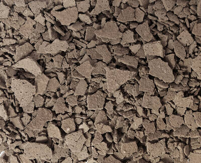 Close-up view of rough, fragmented brown stones or aggregates, creating a textured, uneven surface.