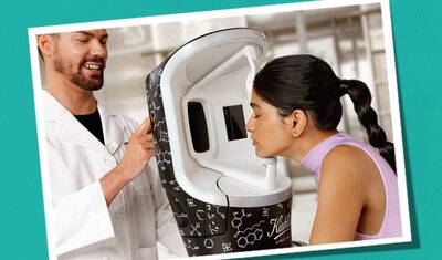 Kiehl's skincare specialist assists a customer using a branded skin analysis device for personalized product recommendations.​