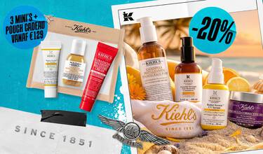 Een zomerse promotiebanner van Kiehl's met de titel "Vos Secrets de Beaute pour l'ete". De afbeelding toont diverse producten op een strandachtergrond.