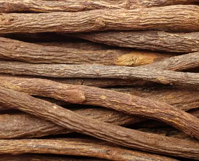 A close-up of various brown sticks, showcasing their rough texture and natural patterns, arranged tightly together.