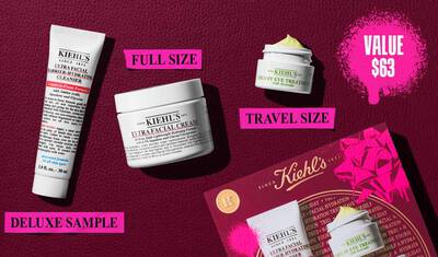 Une image, sur un fond texture rouge fonce, presente trois produits et une boite cadeau. Un tube blanc de "KIEHL’S ULTRA FACIAL BARRIER-HYDRATING CLEANSER" est etiquete "DELUXE SAMPLE" en rose vif. Un pot blanc de "KIEHL’S ULTRA FACIAL CREAM" est etiquete "FULL SIZE" en rose vif. Un petit pot blanc de "KIEHL’S CREAMY EYE TREATMENT WITH AVOCADO" avec une creme jaune pale visible est etiquete "TRAVEL SIZE" en rose vif. Dans le coin inferieur droit, une boite cadeau rouge Kiehl’s presentant les trois memes produits est visible, decoree d'eclaboussures de peinture graphique rose vif et d'un motif de noeud. Dans le coin superieur droit, une eclaboussure de peinture rose vif contient le texte "VALUE $63."