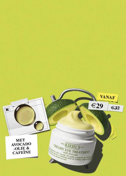 Een promotionele banner van het merk Kiehl's tegen een effen, limoengroene achtergrond met een lichte textuur. Centraal onderaan staat een geopende witte pot van de "Kiehl's Creamy Eye Treatment with Avocado" oogcreme, waaruit de lichtgele, romige textuur naar boven krult. De pot is speels vormgegeven als een klassieke wekker, compleet met zilveren metalen pootjes aan de onderkant en een wekkerbel aan de bovenkant. Achter de pot liggen twee helften van een verse, rijpe avocado. Aan de linkerkant hangt een klein wit fotootje in Polaroid-stijl, vastgeplakt met tape, waarop glanzende druppels olie (avocado-olie) te zien zijn.