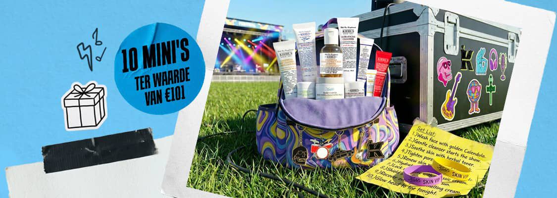 "Een promotionele banner van het verzorgingsmerk Kiehl's met een festivalthema. Links toont een polaroidfoto een kleurrijke reistas gevuld met tien verschillende mini-producten van Kiehl's (zoals cleansers en cremes), versierd met muzikale sleutelhangers. De tas staat op het gras naast een zwarte flightcase vol met vrolijke stickers van gitaren en hoofdtelefoons. Ervoor ligt een gele ""Set List"" met een stappenplan voor huidverzorging en twee festivalbandjes met de tekst ""Kiehl's SKIN VIP"". Op de foto is een opvallende blauwe sticker geplaatst met de tekst ""10 MINI'S TER WAARDE VAN €101"". De rechterkant van de banner is lichtblauw met een minimalistische tekening van een cadeauverpakking, bliksemschichten en een stuk zwarte gaffertape op gescheurd wit papier.  "