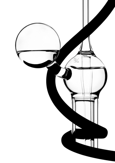 Een abstracte compositie van heldere glasobjecten en een zwarte lijn die ze omwikkelt, met een minimalistische stijl.