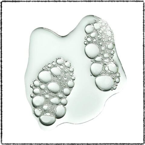 A clear liquid with bubbles arranged in the shape of two footprints on a white background.