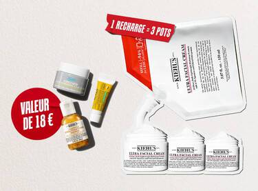 Trois produits de soin pour la peau Kiehl's en format voyage (la creme Ultra Facial Cream, la lotion Calendula Herbal-Extract Toner et le soin contour des yeux Avocado Eye Cream) sont disposes sur un fond blanc texture. Au centre, un cercle rouge peint a la brosse contient l'inscription en blanc "WAARDE VAN €18" (valeur de 18 €).
