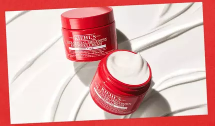 Twee open rode potten Kiehl's Ultra Facial Meltdown Recovery Cream op een witte achtergrond met gladde cremekleurige krullen, tegen een rode rand.