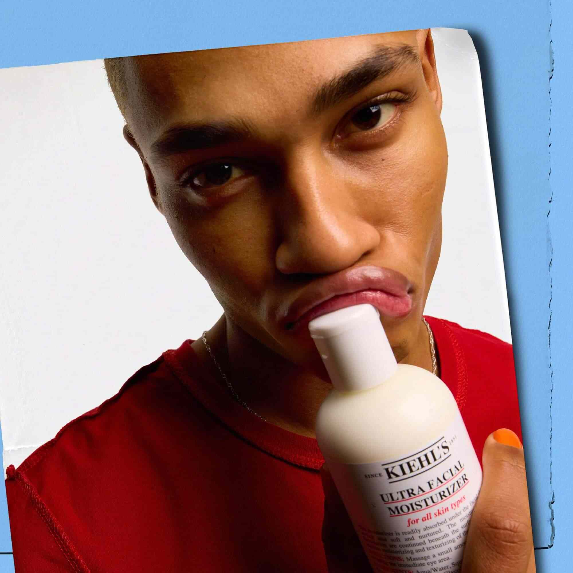 Mannequin pressant un flacon de Kiehl's Ultra Facial Moisturizer contre ses levres