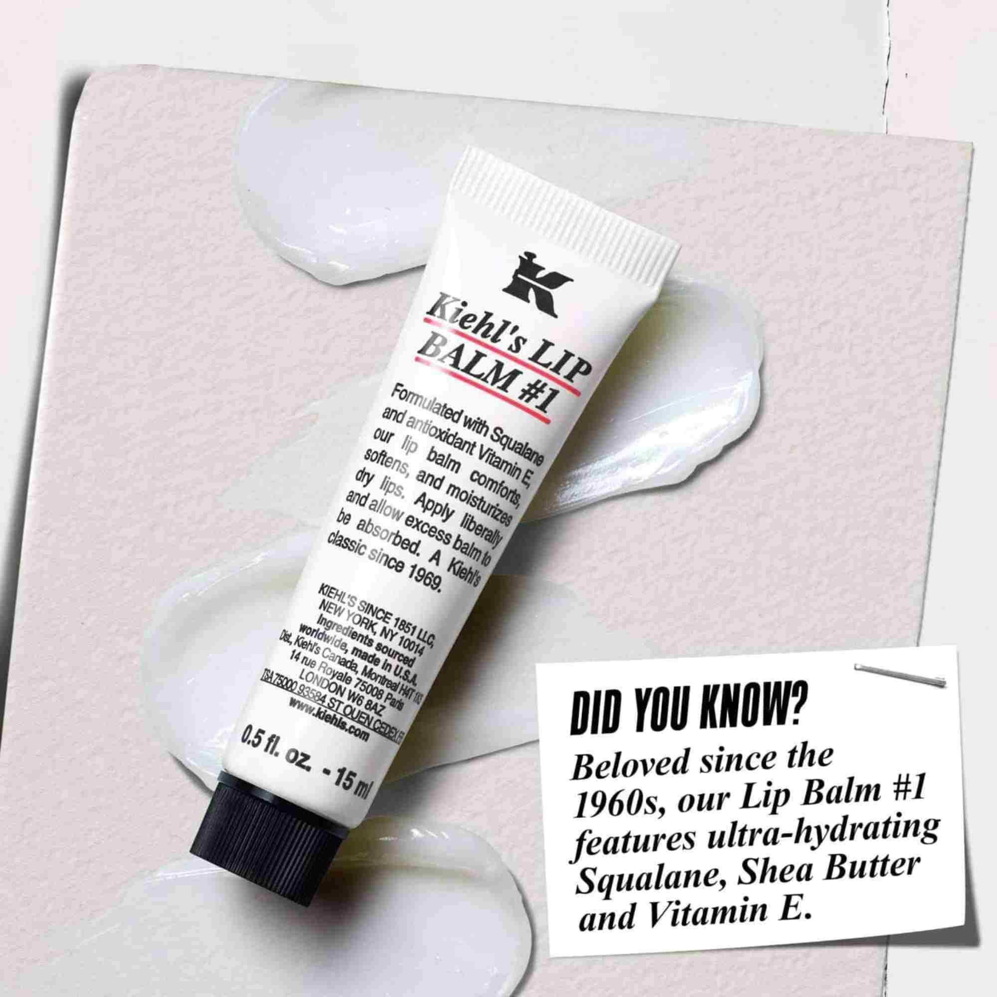 Een tube Lip Balm #1 op een wit oppervlak met de tekst: "Wist je dat? Geformuleerd met squalaan, sheaboter en vitamine E voor gehydrateerde, gladdere lippen."
