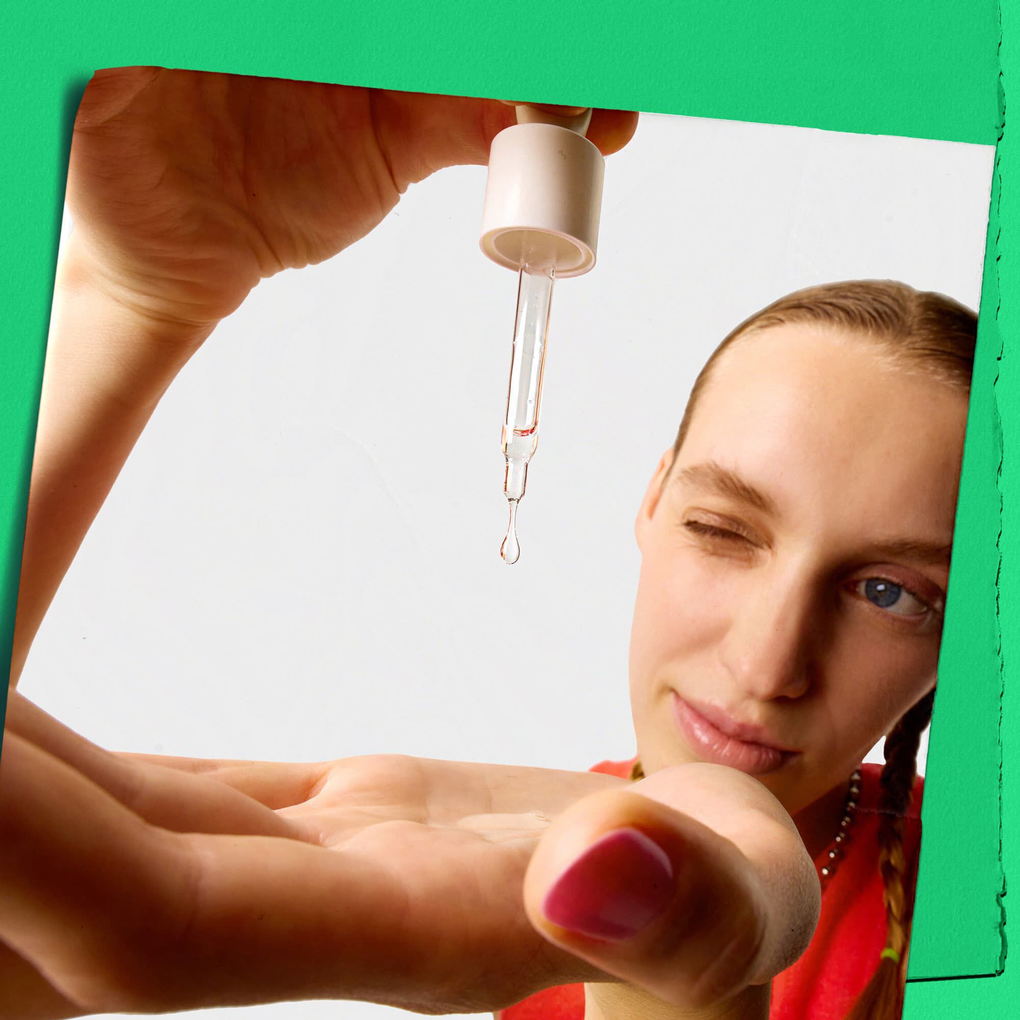 Model druppelt Kiehl's Ultra Pure High-Potency Serum op de hand