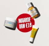 Drie reisformaat huidverzorgingsproducten van Kiehl's (de Ultra Facial Cream, de Calendula Herbal-Extract Toner en de Avocado Eye Cream) liggen verspreid op een witte, gestructureerde achtergrond. In het midden staat een rode, geverfde cirkel met de witte tekst 'WAARDE VAN €18'.