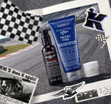 Een collage in vintagestijl met raceauto's, een geblokte vlag en verschillende huidverzorgingsproducten van Kiehl's, waaronder de Facial Fuel- en Age Defender-lijnen, tegen een achtergrond van een racebaan.